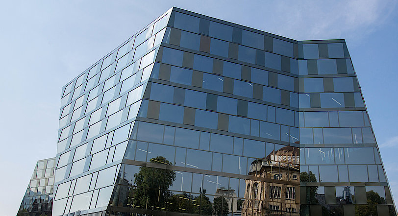 Fassade der UB Freiburg mit Spiegelung des Stadttheaters.